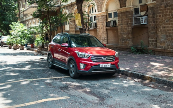 A red suv is parked on a street.